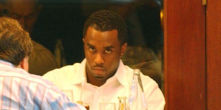Man in a white shirt at a table with drinks, looking intently at the person across from him.