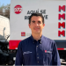 Man in a navy uniform standing in front of a branded delivery truck with MTY graphics in red and blue.